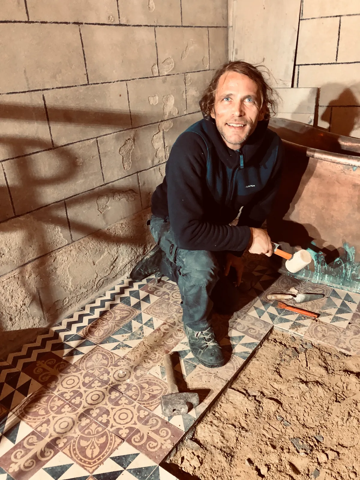 Luc, à genoux, pendant les travaux dans la salle de bain de l’église